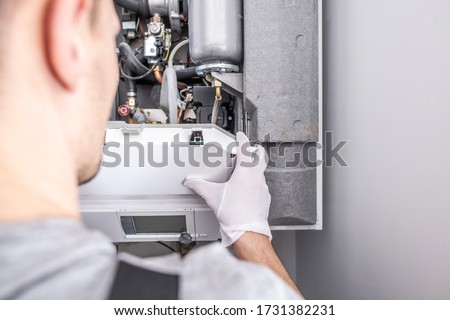 Close Up Of Caucasian Service Worker Fixing Central Heating Furnace System. 