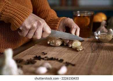 Close up of caucasian woman cutting ginger in kitchen  - Shutterstock ID 2226150433