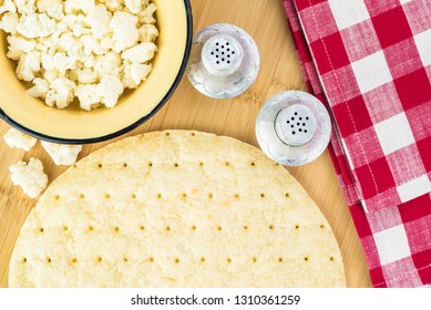 Close Up Of Cauliflower Pizza Crust On A Cutting Board.