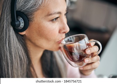 Close Up Of Charming Woman Sipping Favorite Hot Drink And Looking Away With Serene Expression