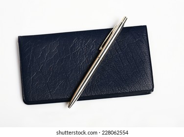 Close Up Of A Check Book And Silver Pen