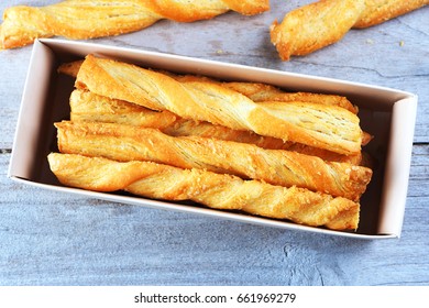 Close up of cheese bread sticks in a box on a wooden background.