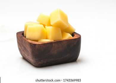 Close Up Of Cheese Cubes In Wooden Bowl Isolated White Background.