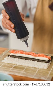 Close Up Chef Making Sushi. Sushi Roll Process Adds Sauce To Sushi