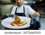 Close up of chef serving a dish in restaurant. 