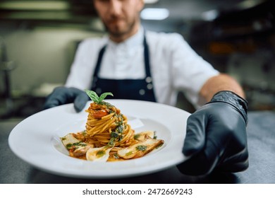 Close up of chef serving a dish in restaurant. 