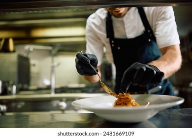 Close up of chef serving pasta in the kitchen.  - Powered by Shutterstock