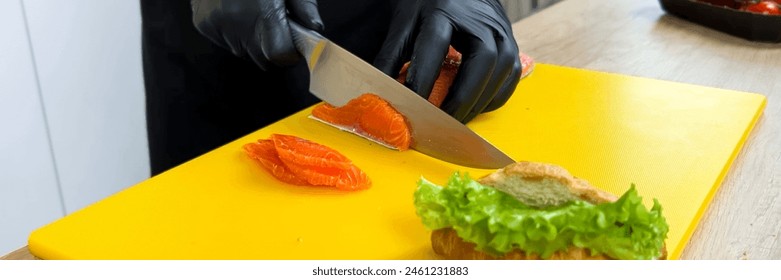 Close up of chef slicing fresh salmon on a yellow cutting board for sushi preparation, conceptually related to culinary arts and healthy eating - Powered by Shutterstock