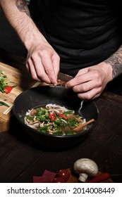 Close Up Of Chef's Hands Adding Spices To Asian Pho Bo Dish, Cooking In Studio