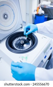 Close Up Of A Chemist Using A Centrifuge In Lab