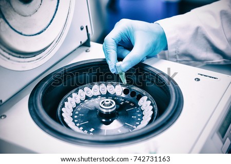 Close up of a chemist using a centrifuge in lab