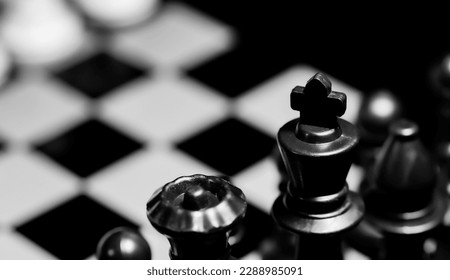 Close up of Chess pieces on a reflective mirror board surface with a plain black background - Powered by Shutterstock