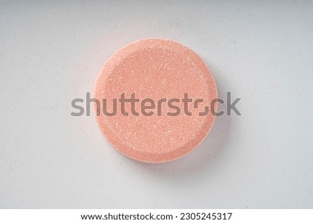 Close up of of chewable antacid acid reducer tablets with fruit flavor on white paper background