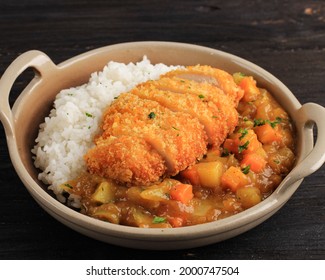 Close Up Chicken Katsu With Japanese Curry, Serve With White Rice On Brown Ceramic Plate Above Wooden Table, Isolated On Black Table With Copy Space For Text Or Recipe