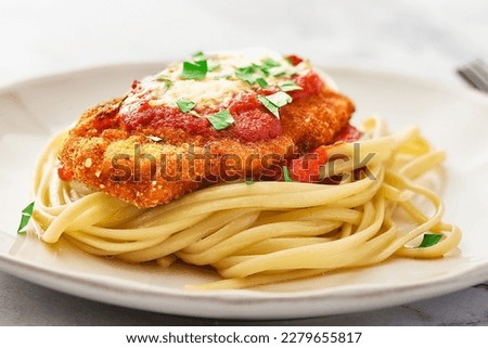 Close up Chicken Parmesan and spaghetti in a plate. Low angle view. Macro shot with focus stacking.
