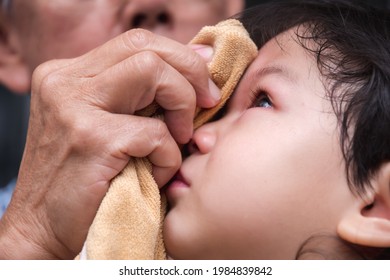 Close Up Child Face Cried From A Head Injury. Grandfather Wrapped Ice Cubes In A Cloth And Put A Cold Compress On The Little Boy. Children Aged 2-3 Years Old.