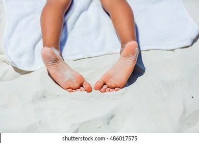 Close Up Of Child Feet On Beach Towel On Tropical White Beach