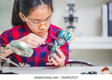Close up of Child girl student build robotic cars, kid learning programming robot vehicles
