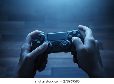 Close up of child hands playing the video game at night - Powered by Shutterstock
