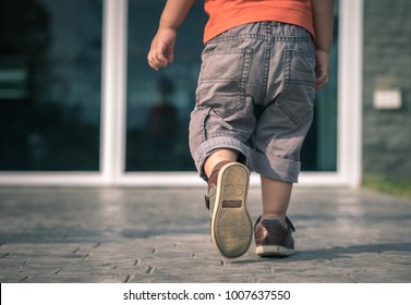 Close Up Of Child Legs Walking Away From Camera Toward House Door