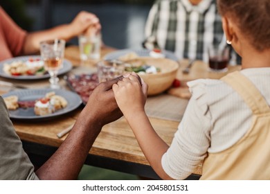 Close Up Of Children Holding Hands At Family Dinner Outdoors And Praying, Copy Space