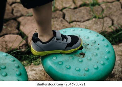 close up of child's feet are walking on the playground footbridge, path of balance - Powered by Shutterstock