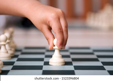 Close Up For Child's Hand Playing Chess