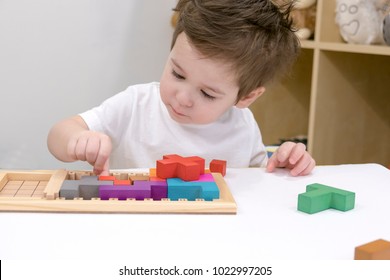 Close up of child's hands playing with colorful wooden bricks at the table.