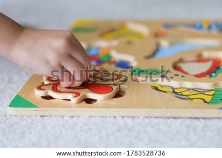 Close up of a child's hands while playing with toy puzzle blocks. 