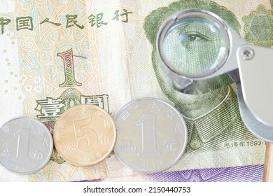 Close Up Of Chinese Banknotes, Magnifying Glass And Coin. Chinese Yuan, CNY, RenMinBi, RMB(People's Replublic Of China Money). Finance Concept.