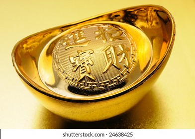 Close Up Of Chinese Gold Ingot Over Golden Background