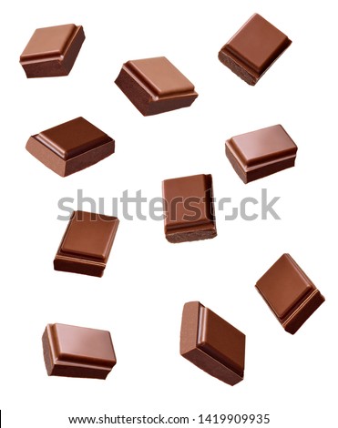 close up of chocolate pieces stack falling on white background