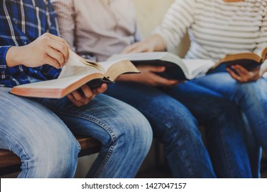 close up of christian group hold and opening bible page while reading and study bible together with friends in Sunday school class room
