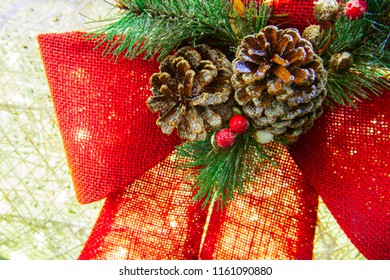 Close Up Of Christmas Wrath With Pine Cones And Red Burlap Ribbon