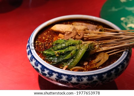 close up chuan chuan xiang. Sliced meat and vegetable on bamboo skewer in spicy soup. Traditional snack in Chengdu Sichuan China