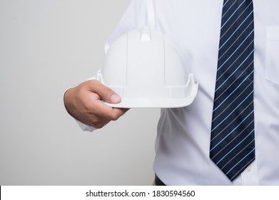 Close Up Civil Engineer Holding Helmet Hard Hat Standing Post In Studio On Isolated White Background. Architecture Or Engineer Concept.