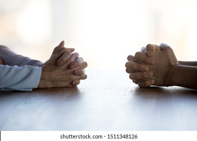 Close up clasped female hands of two businesswomen negotiate at table, confrontation concept, negotiators conflict, employees struggle for leadership at work, difficult job interview, hiring decision