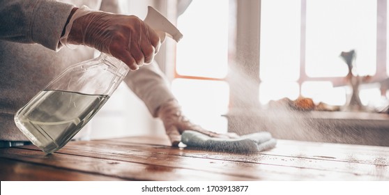 Close Up Of Cleaning Home Wood Table, Sanitizing Kitchen Table Surface With Disinfectant Antibacterial Spray Bottle, Washing Surfaces With Towel And Gloves. COVID-19 Prevention Sanitizing Inside.