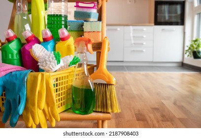 Close up of cleaning products arranged on wooden shelves in front of kitchen. Housekeeping concept - Shutterstock ID 2187908403