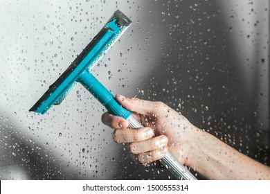 Close Up Cleaning Shower Glass Door With Squeegee