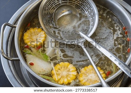 Close up of clear broth base for Chaoshan beef hot pot
