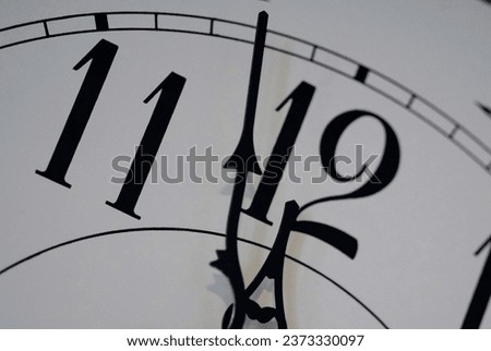 Close up click face with the hands indicating two minutes until 12:00.