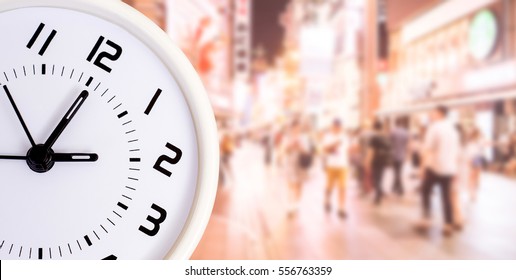 Close up of clock with abstract blur people background - Shutterstock ID 556763359