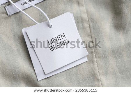 Close up of clothing hang tag. Linen blend product details.	