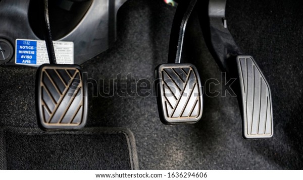 Close up of\
clutch, foot brake and gas on the\
car