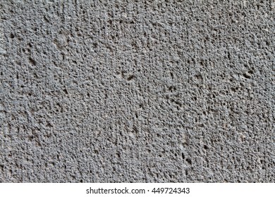 Close up of a coarse, dark gray concrete wall
