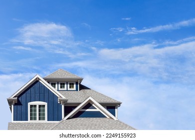 Close up of a coastal style house against a blue cloudy sky