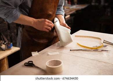 Close up of a cobbler modeling mens shoe at his workshop - Powered by Shutterstock