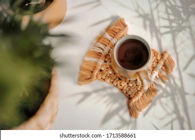 A close up of a coffee cup on boho coaster. Colorful rustic kitchen morning - Powered by Shutterstock