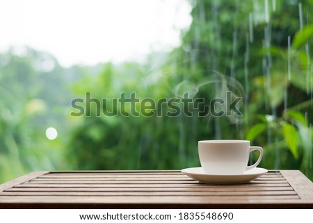 Close up coffee espresso on wood table raining background in garden,